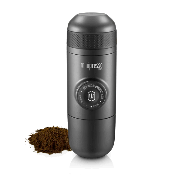 Persona che prepara un espresso con una macchina portatile in montagna.